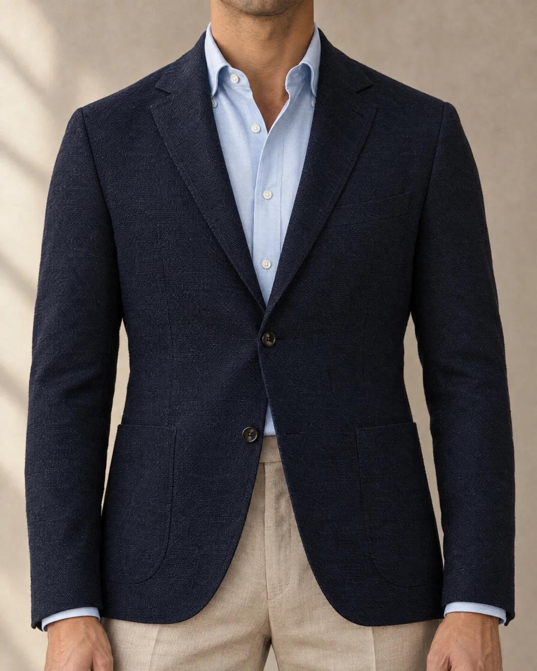 The navy jacket fastened at the top button, the front flat, the quarters open below.